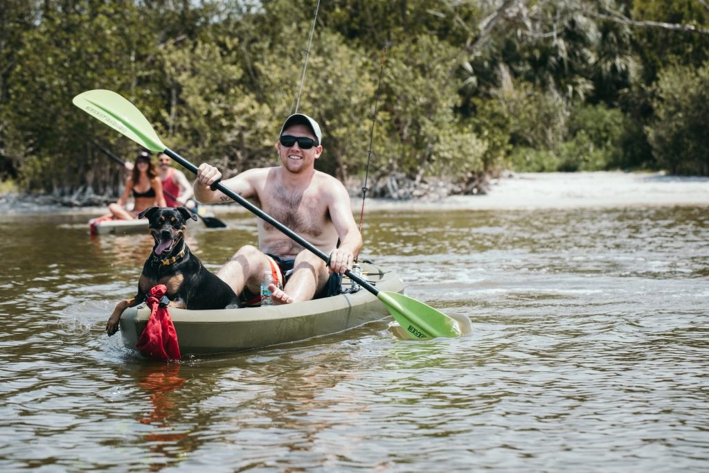 Man paddles with his dog on a tandem fishing kayak
