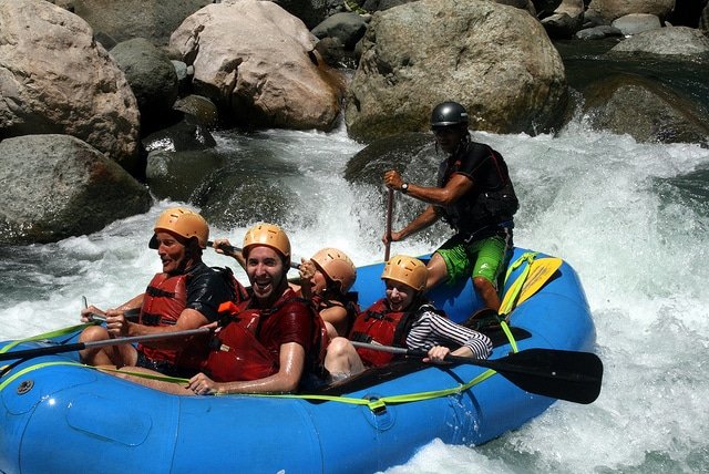 A sturdy whitewater raft navigates rocky rapids. Inflatable kayaks are often made of the same durable materials as these rafts. 