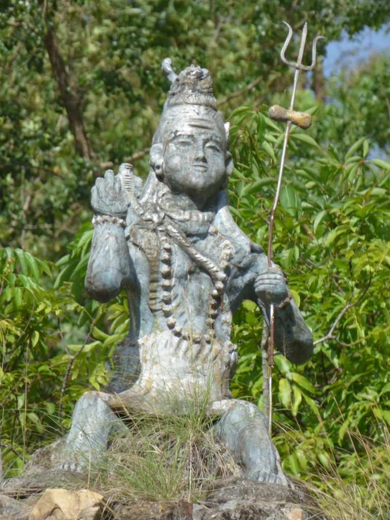 A statue of Lord Shiva overlooks a river in Nepal