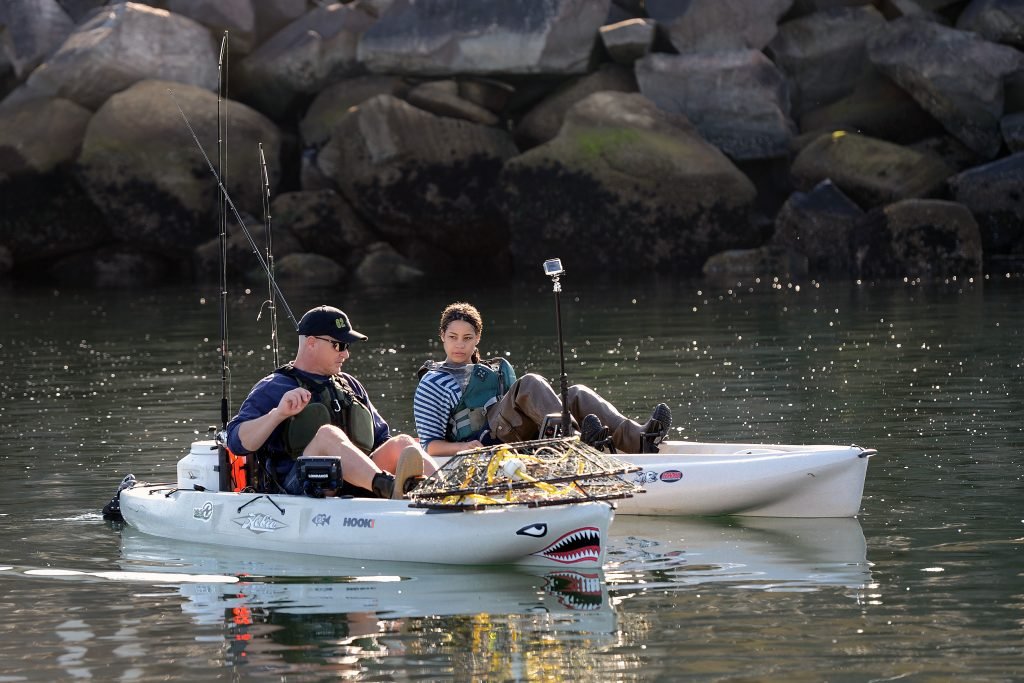 Two kayak anglers paddle to their fishing spot