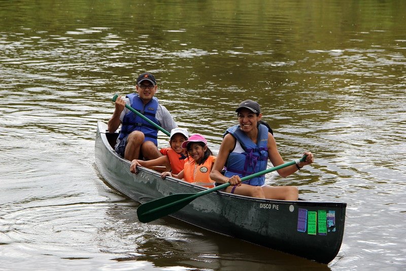A family of 4 comfortably paddles a canoe